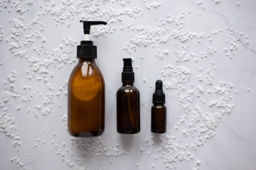 Amber glass skincare bottles arranged on a white marble surface