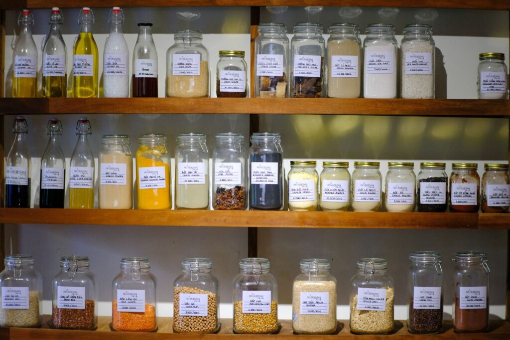 Glass jars of pantry ingredients neatly arranged on wooden shelves